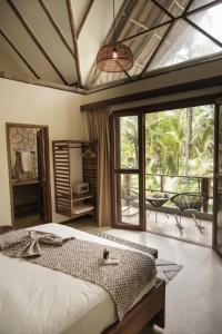 una camera da letto con un letto e una grande finestra di Tay Beach Hotel Tayrona a Buritaca