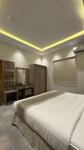a bedroom with a large bed and a desk at شقق اركان الريم للوحدات السكنية in Al Thybiyah +2 photos