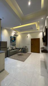 a large living room with a couch and a tv at شقق اركان الريم للوحدات السكنية in Al Thybiyah