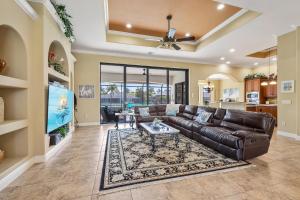 een woonkamer met een leren bank en een tafel bij Villa Pearl in Matlacha