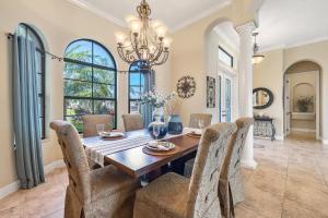 een eetkamer met een tafel, stoelen en een kroonluchter bij Villa Pearl in Matlacha
