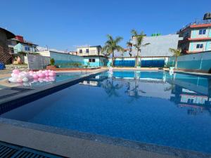 a swimming pool with blue water and pink balloons at Universal Bliss in Pokhara