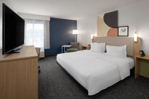 een hotelkamer met een wit bed en een flatscreen-tv bij Spark by Hilton Decatur in Decatur