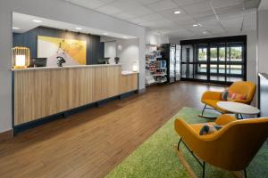 een kantoorlobby met receptiebalie en stoelen bij Spark by Hilton Decatur in Decatur
