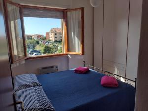 ein Schlafzimmer mit einem blauen Bett mit zwei rosa Kissen in der Unterkunft EMAsolemare in Rosignano Solvay