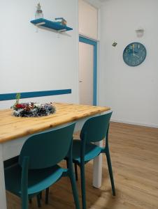 einen Esstisch mit 2 Stühlen und einer Uhr in der Unterkunft EMAsolemare in Rosignano Solvay + 7 Fotos
