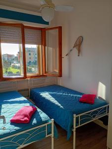 zwei Betten in einem Zimmer mit zwei Fenstern in der Unterkunft EMAsolemare in Rosignano Solvay