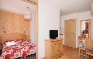 - une chambre avec un lit, une télévision et une table dans l'établissement Résidence Odalys Le Grand Panorama 1, à Valmeinier