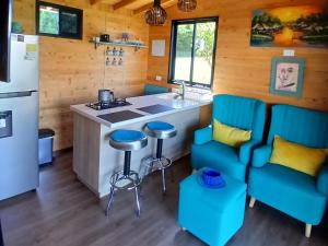 a kitchen with blue chairs and a counter at Cabaña Martina con Jacuzzi in Marinilla