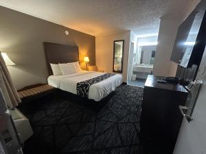 a hotel room with a bed and a bathroom at New Travel Inn in Kingsport