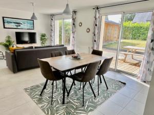 ein Esszimmer mit einem Holztisch und Stühlen in der Unterkunft Le Belaven, Neuf, Cosy, Terrasse, jardin, Kerfany Plage, 1 à 6 pers in Moëlan-sur-Mer + 44 Fotos