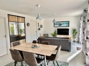 ein Wohnzimmer mit einem Tisch und einem Sofa in der Unterkunft Le Belaven, Neuf, Cosy, Terrasse, jardin, Kerfany Plage, 1 à 6 pers in Moëlan-sur-Mer