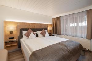a bedroom with a large bed and a window at Hotel Grindelwalderhof in Grindelwald +38 photos