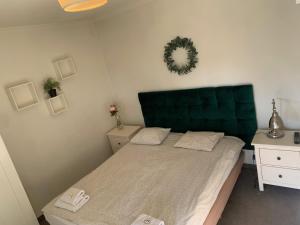 a bedroom with a bed with a green headboard at Boleslav Home in Sucha Beskidzka