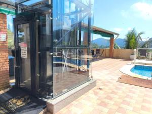 een glazen uitbreiding naar een huis met een zwembad bij Hospedaria Vitória Mar in Ubatuba +111 foto's