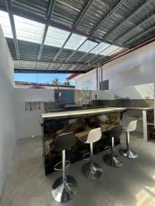 a kitchen with a counter with four bar stools at Casa B Pasco in Dauin +44 photos