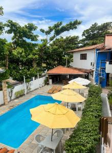 a group of yellow umbrellas and a swimming pool at Pousada Rota Beach in Porto De Galinhas