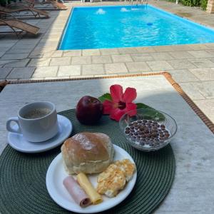 a table with a plate of breakfast food and a cup of coffee at Pousada Rota Beach in Porto De Galinhas