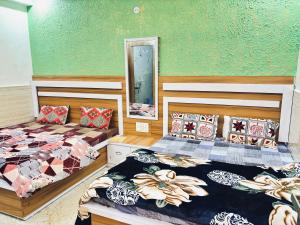 a room with two beds and a mirror at Madhu Stay in Chhatikara