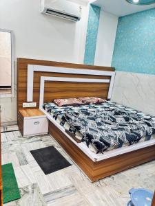 a bedroom with a bed with a black and white comforter at Madhu Stay in Chhatikara
