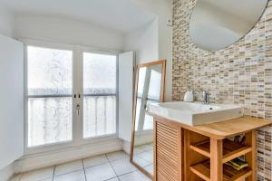 a bathroom with a sink and a mirror at Studio Alienor Place la Bourse Bordeaux in Bordeaux