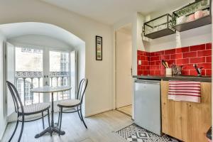 a kitchen with a table and chairs and a sink at Studio Alienor Place la Bourse Bordeaux in Bordeaux +17 photos