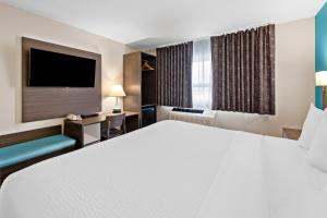 a hotel room with a large bed and a tv at Howard Johnson by Wyndham Thunder Bay in Thunder Bay +37 photos