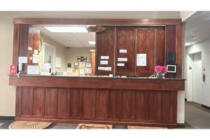 a lobby with a reception counter with a mirror at Pleasant Night Inn Carthage Near Fort Drum in West Carthage