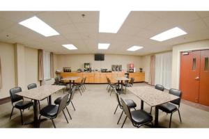 een vergaderzaal met tafels en stoelen en een balie bij Pleasant Night Inn Watertown by Hotel O in West Carthage