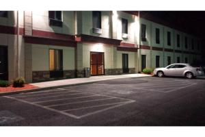 a car parked in a parking lot in front of a building at Pleasant Night Inn Carthage Near Fort Drum in West Carthage