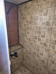 un bagno con doccia con parete in pietra di Cabaña Jacinta a La Boca