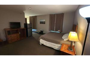 een hotelkamer met een bed en een televisie bij Pleasant Night Inn Watertown by Hotel O in West Carthage