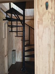 una scala a chiocciola in una camera con pareti in legno di Cabaña Jacinta a La Boca