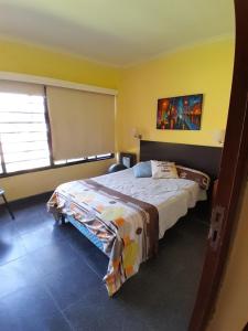 een slaapkamer met een bed in een gele kamer bij Museo Mar in Mar del Plata