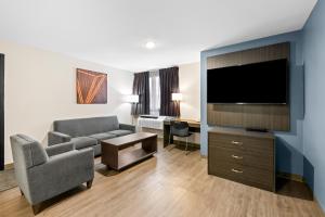a living room with a couch and a flat screen tv at Howard Johnson by Wyndham Thunder Bay in Thunder Bay