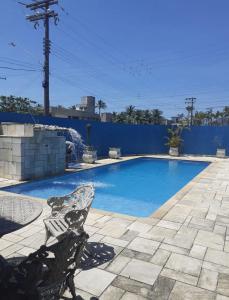 een zwembad met een bankje ervoor bij Pousada Blue Beach House in Peruíbe