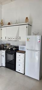 een keuken met een fornuis en een witte koelkast bij Martha's House Tesla in Soufrière