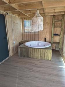 una grande vasca da bagno in una stanza con un lampadario a braccio di Cabaña Jacinta a La Boca