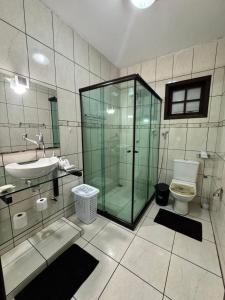 een badkamer met een glazen douche en een toilet bij Loft Ilha Grande in Angra dos Reis