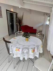 een witte tafel met stoelen en een rode bank bij Loft Ilha Grande in Angra dos Reis +4 foto's