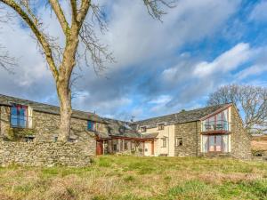 una vista esterna di una casa in pietra con un albero di 4 Bed in Broughton Mills 75286 a Seathwaite
