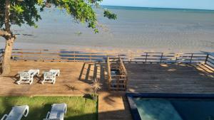 a deck with chairs and a view of the beach at kitnets Praia Super in Cumuruxatiba