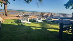 a group of chairs sitting around a picnic table at kitnets Praia Super in Cumuruxatiba +5 photos