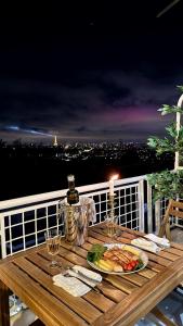 een houten tafel met een bord eten en wijn bij Vue Paris 1 min de la gare in Saint-Cloud