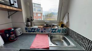een kleine keuken met een wastafel en een raam bij Vue Paris 1 min de la gare in Saint-Cloud +36 foto's