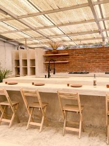 a kitchen with a counter with two chairs and a sink at Co404 Oaxaca - Coliving Coworking in Oaxaca City