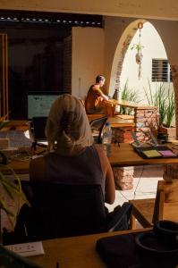 a woman sitting at a table in a room at Co404 Oaxaca - Coliving Coworking in Oaxaca City