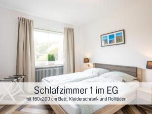 una camera da letto con un letto e una finestra di Ferienhaus Robbenglück in Tossens - Ihr gemütliches Zuhause an der Nordsee a Tossens Altre 48 foto
