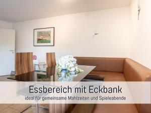 un soggiorno con un divano e un tavolo di Ferienhaus Robbenglück in Tossens - Ihr gemütliches Zuhause an der Nordsee a Tossens