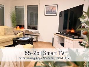un soggiorno con una grande TV a schermo piatto di Ferienhaus Robbenglück in Tossens - Ihr gemütliches Zuhause an der Nordsee a Tossens